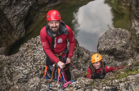 Der Canyoning-Guide in Salzburg lacht gemeinsam mit einer jungen Frau in die Kamera