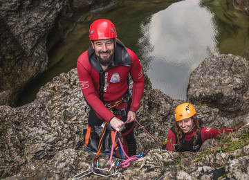 Ein Man uns eine Frau lachen beim Canyoning im Salzkammergut in die Kamera