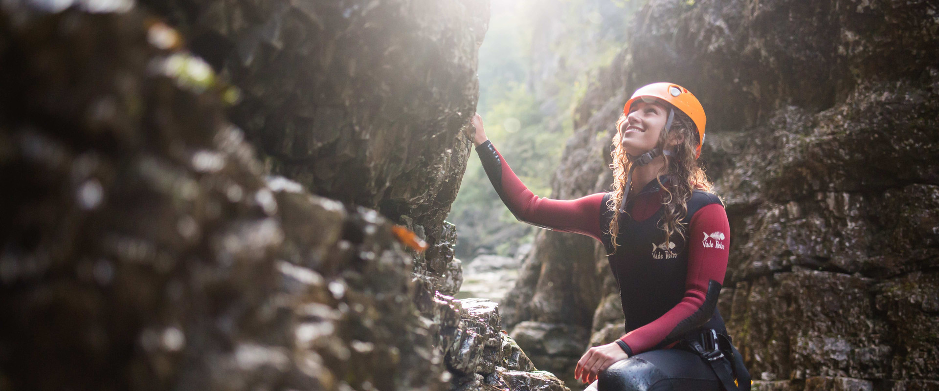 Beim Canyoning im Wiestal schaut eine junge Frau lächelnd die Felswand hinaus