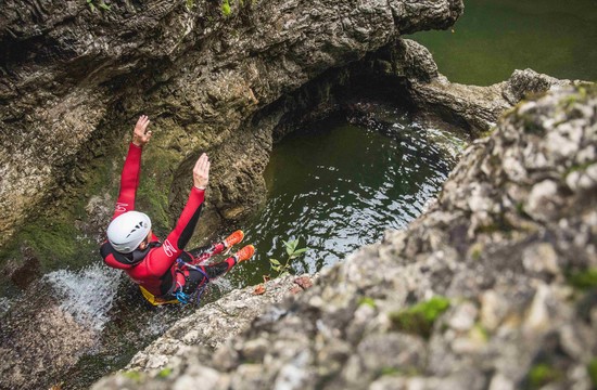 Bei einer Canyoning-Tour mit Max Obermayr rutscht ein Mann über die nassen Felsen ins Wasser