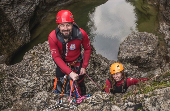 Beim Canyoning für Familien überprüft eine junge Frau die Sicherung